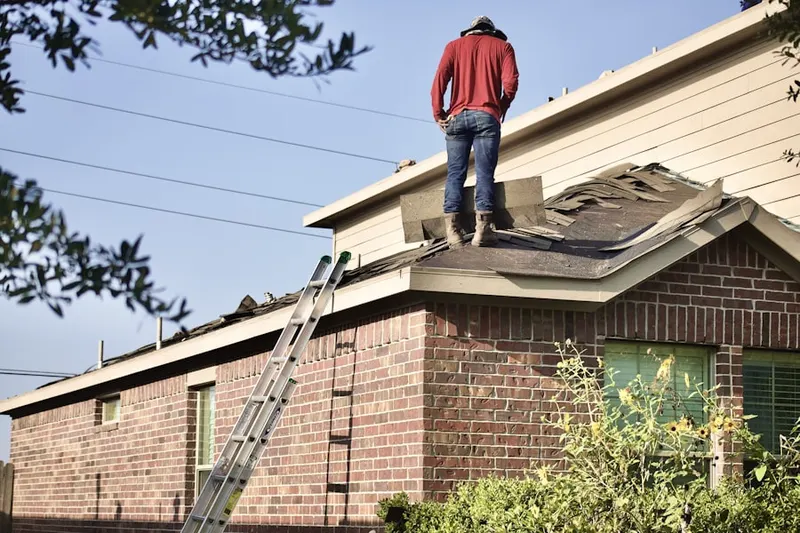 Professional roofer working on a residential roof in Mack